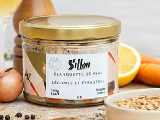 Bocal en verre de la marque Sillon contenant une blanquette de veau aux légumes et épeautres, présenté sur une table avec des ingrédients bruts (oignon, citron, carottes, grains d’épeautre) en arrière-plan. L’étiquette mentionne une fabrication artisanale en France et une portion de 360 g. L’ensemble évoque une cuisine de terroir authentique et soignée.