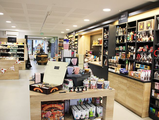 Intérieur de l’Épicerie du Porche à Acigné, avec rayonnages de produits fins, présentoirs de spécialités locales, et une ambiance chaleureuse et moderne.