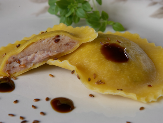 Ravioles de La Ferme des 7 Fontaines, garnies de perdreau et graines de sésame torréfiées, présentées avec une sauce et graines grillées.