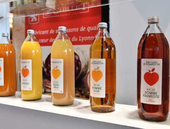 Bouteilles de jus de pomme exposées lors de l'édition 2025 du salon Gourmet Selection