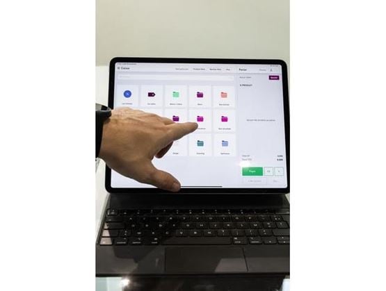 une main avec l'index pointant vers une tablette tactile