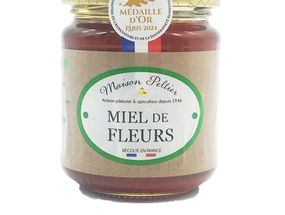 Pot en verre de miel de fleurs Maison Pellier avec étiquette verte et beige indiquant « Miel de Fleurs », récolté en France, avec une médaille d’or Paris 2024 sur le couvercle.