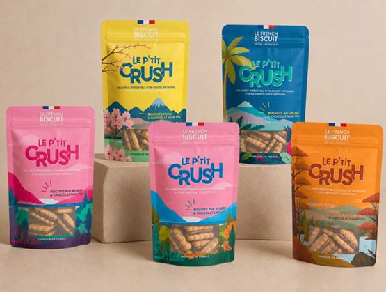 Cinq sachets colorés de biscuits artisanaux Le P’tit Crush sont présentés sur des blocs beiges.