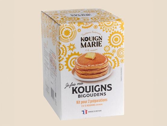 Boîte de kit Kouign Marie pour préparer des kouigns bigoudens, illustrée avec une pile de crêpes épaisses et des motifs jaunes.