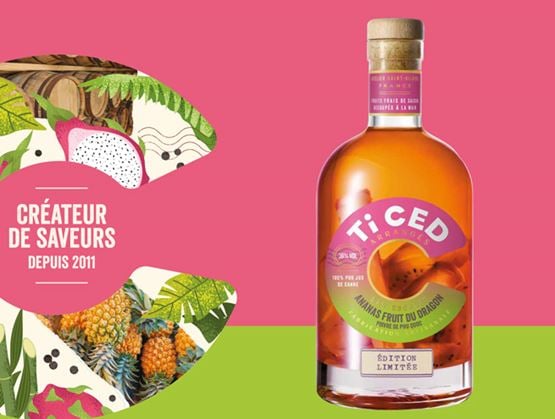 Bouteille Ti Ced’ Arrangés en édition limitée à l’ananas fruit du dragon, présentée sur un fond rose et vert avec des illustrations tropicales.