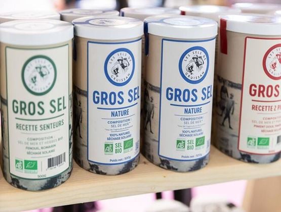 Boîtes de gros sel bio alignées sur une étagère.