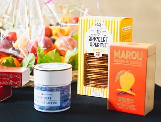Sélection de produits alimentaires emballés, dont des biscuits apéritifs, une confiture et une tablette de chocolat.