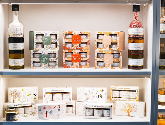 Étagère d’épicerie fine présentant des bouteilles et une sélection de coffrets alimentaires.