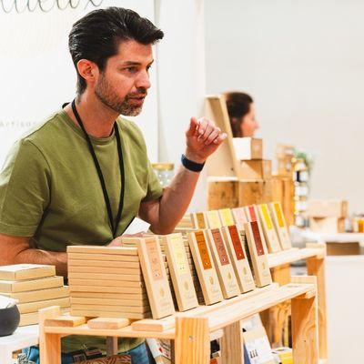 Exhibitor discussing fine food products with visitors at a Gourmet Selection trade show stand.