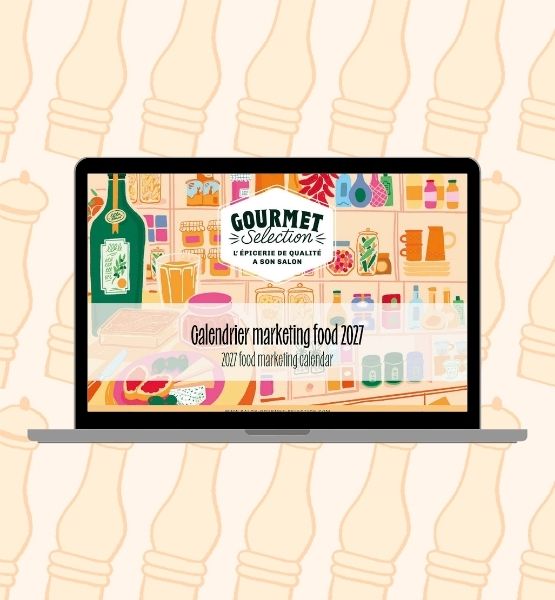 Illustration d’un ordinateur portable affichant le calendrier marketing food 2027 de Gourmet Selection, avec des produits d’épicerie fine en arrière-plan.