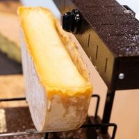Fromage à raclette fondu en cours de chauffe, prêt à être raclé et servi.