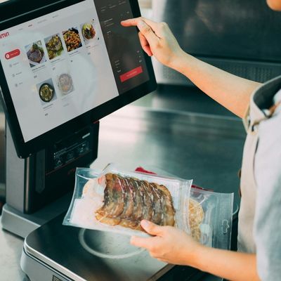 Using a digital display to manage packaged food products, illustrating digital tools and technological solutions in the food retail industry.