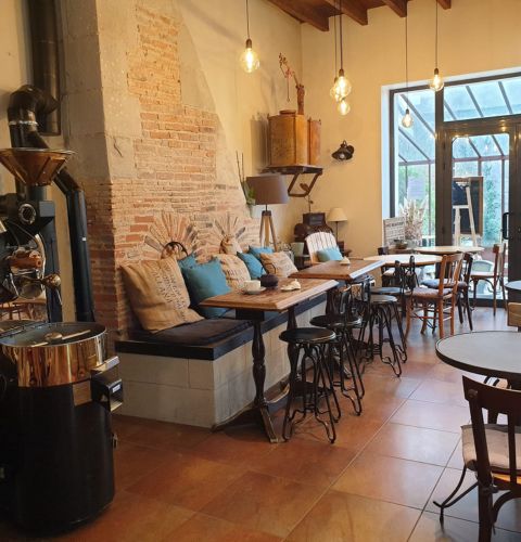 Cozy seating area of L'Instant Divin grocery store, featuring rustic wooden furniture and vintage decor.