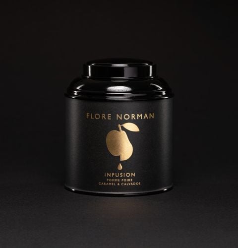 Boîte noire d’infusion pomme poire caramel calvados, photographiée sur fond noir élégant.