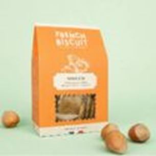 Orange box of savory biscuits displayed on beige background with hazelnuts around the packaging.